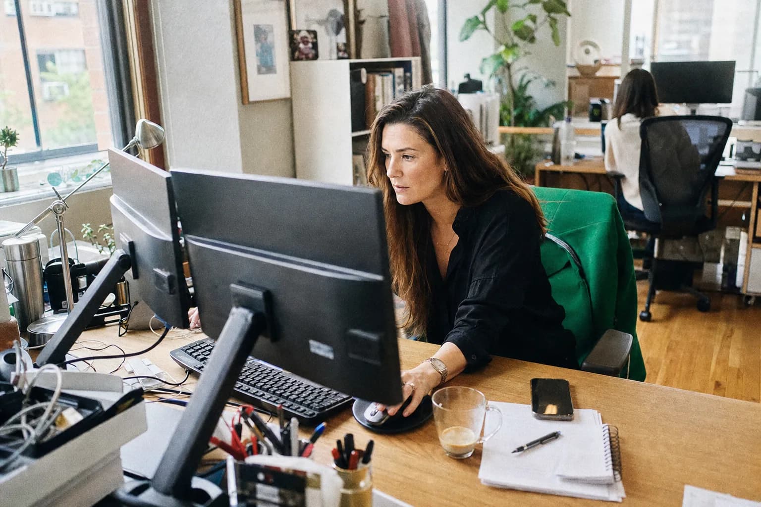 Recruiter werkt geconcentreerd achter twee beeldschermen